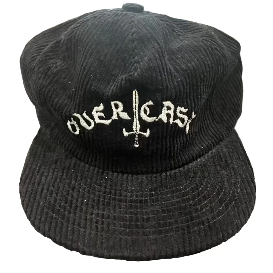 Black corduroy cap with 'OVERLORD' embroidery on a textured surface