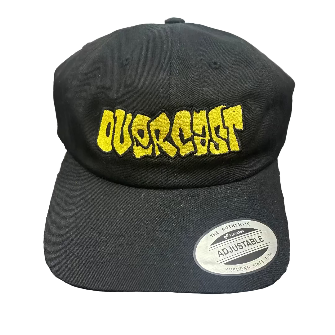 Black cap with yellow text 'OVERCAST' on a textured surface