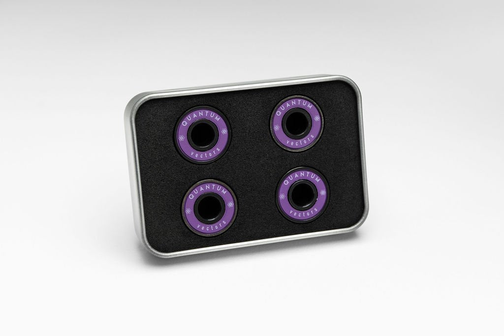 Four purple bearings on a black tray with 'Quantum' branding on a white background